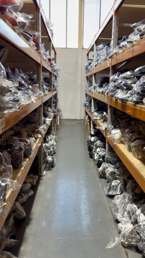 An aisle of shelved and wrapped used car parts at Partsworth